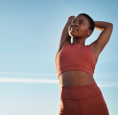 Une femme en tenue de sport s'étire.