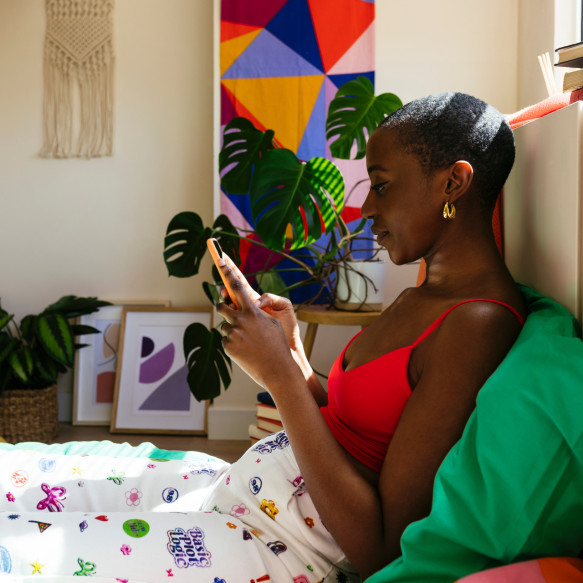 Une femme assise à l'intérieur regarde son téléphone portable