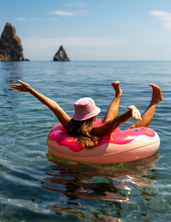 Une fille allongée sur une bouée à la mer.